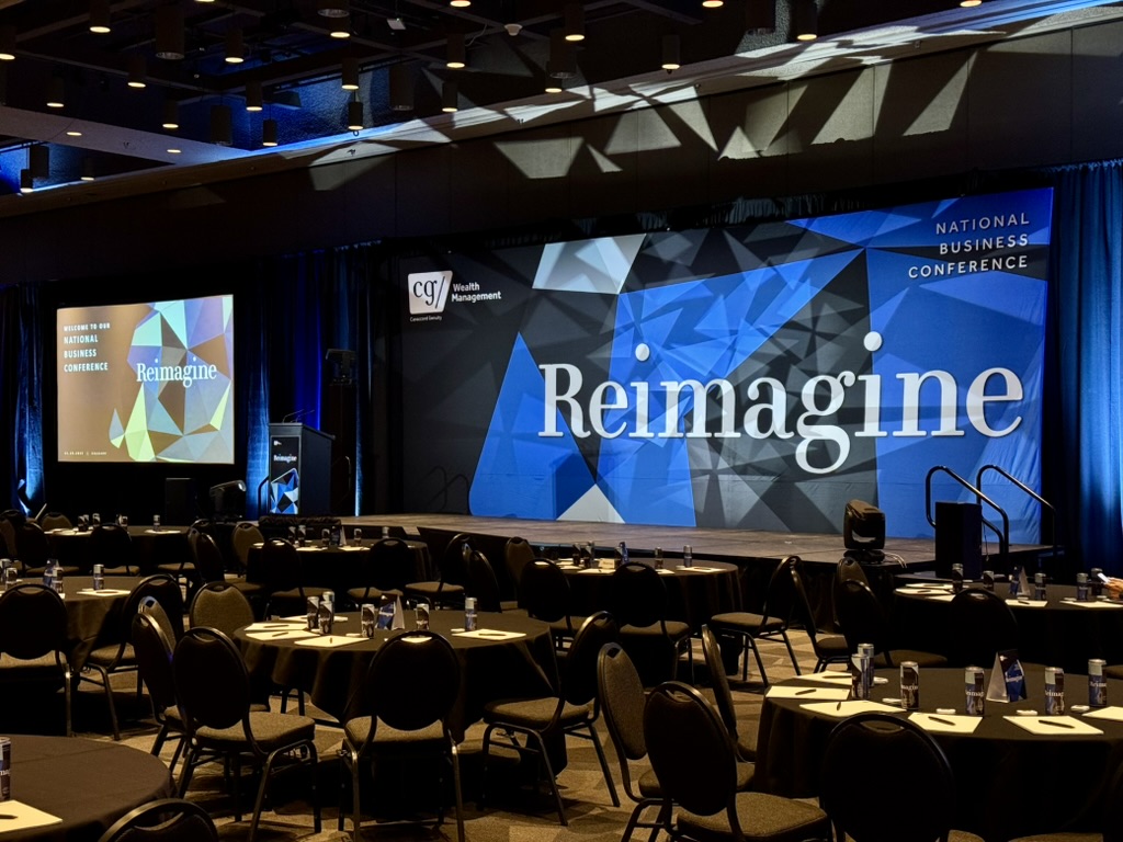 Conference stage with large centre screen, side screens and blue lighting