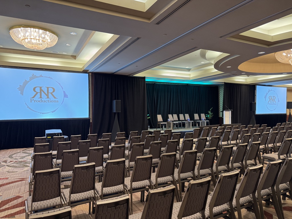 Leadership town hall room with lounge-style stage and three screens